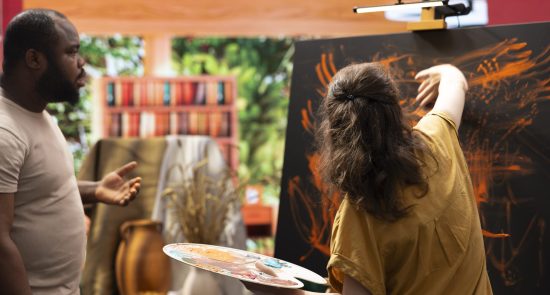 Talented artist and her apprentice engage in finger painting hobby book fair Limpopo